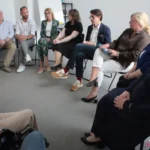 Uczestnicy debaty siedzący w półokręgu